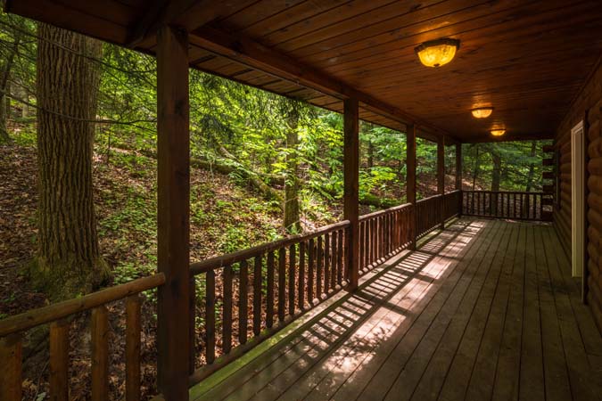 Covered deck overlooking the woods — Leaning Tree Cabin