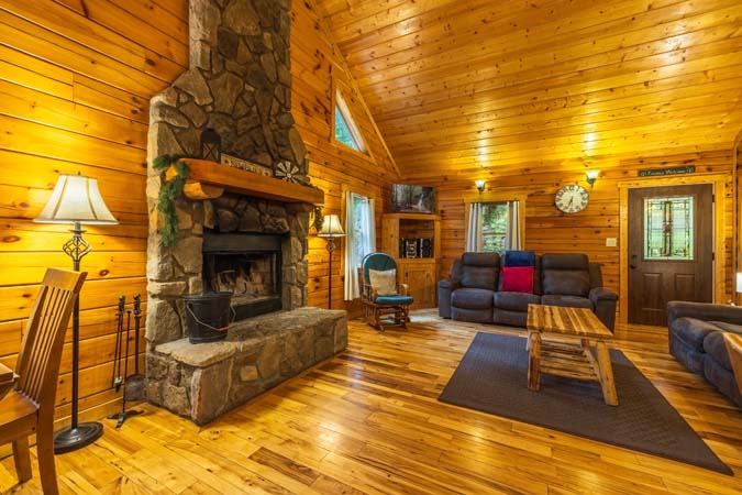 Great room with a stone wood-burning fireplace — Leaning Tree Cabin