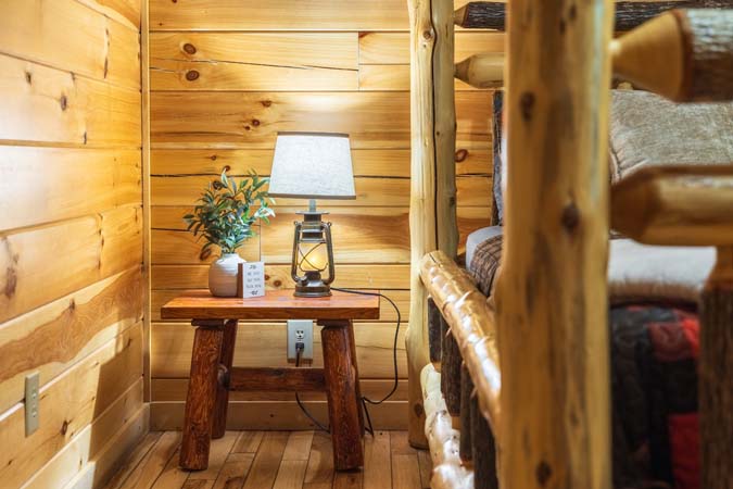 Bedside details in a log bedroom — Timber Ridge Lodge