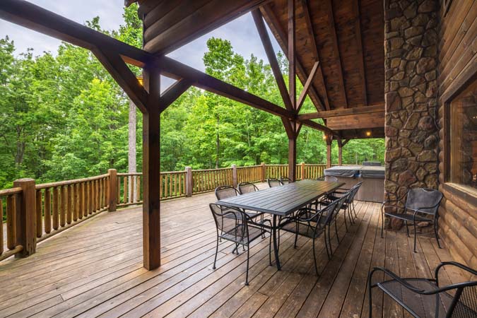 Covered deck dining beside the hot tub — Timber Ridge Lodge