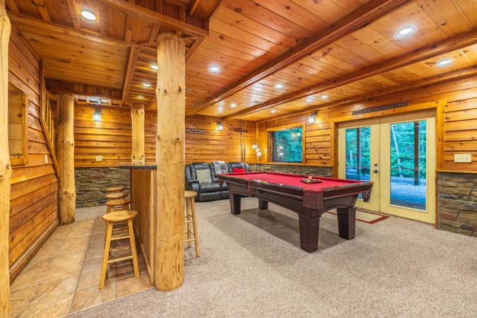Game room with a pool table and walkout — Timber Ridge Lodge